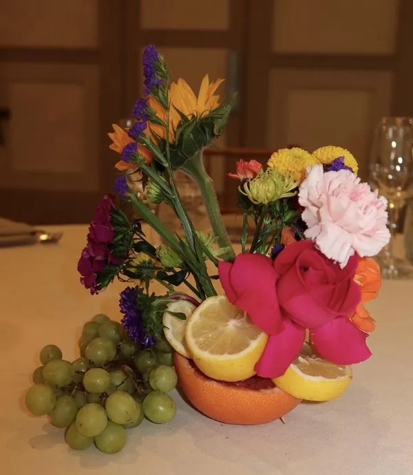 A colorful arrangement of flowers and fruit