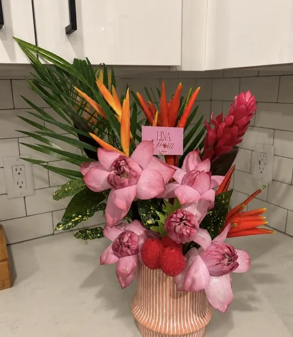 Tropical vase arrangement with pink lotus, heliconia, and ginger